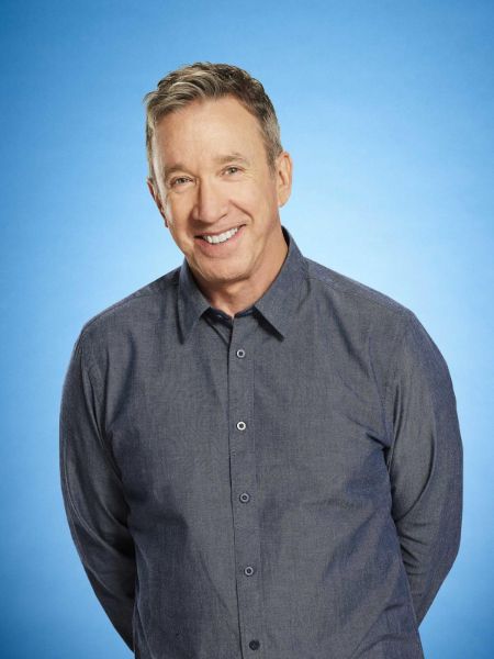 Tim Allen in a grey shirt poses for a picture.